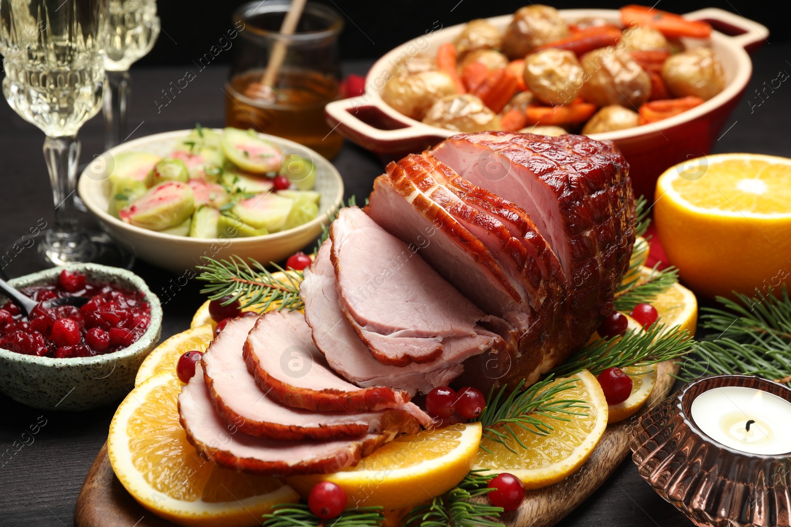 Photo of Tasty baked ham served on black wooden table