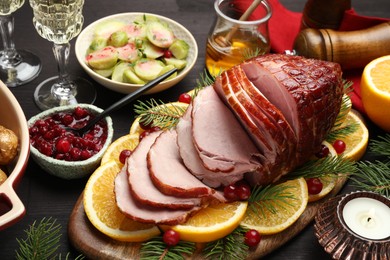 Photo of Tasty baked ham served on black wooden table