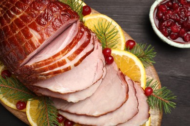 Photo of Tasty baked ham served on black wooden table, flat lay