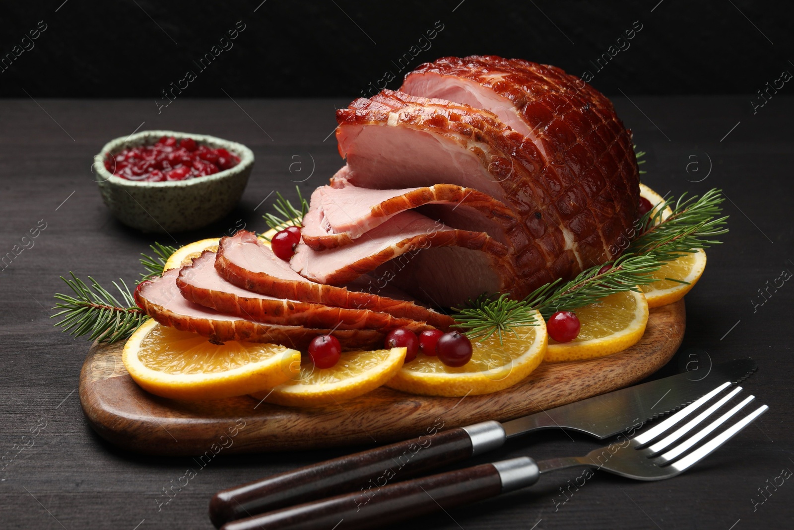 Photo of Tasty baked ham served on black wooden table