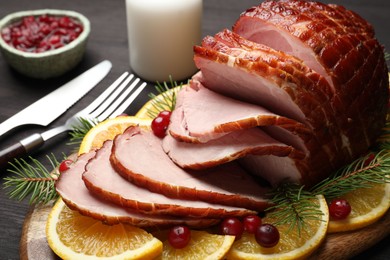 Photo of Tasty baked ham served on black wooden table, closeup