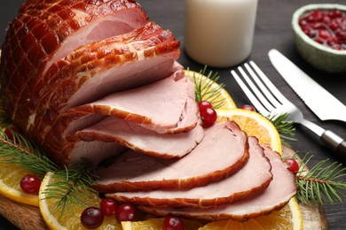 Tasty baked ham served on black wooden table, closeup