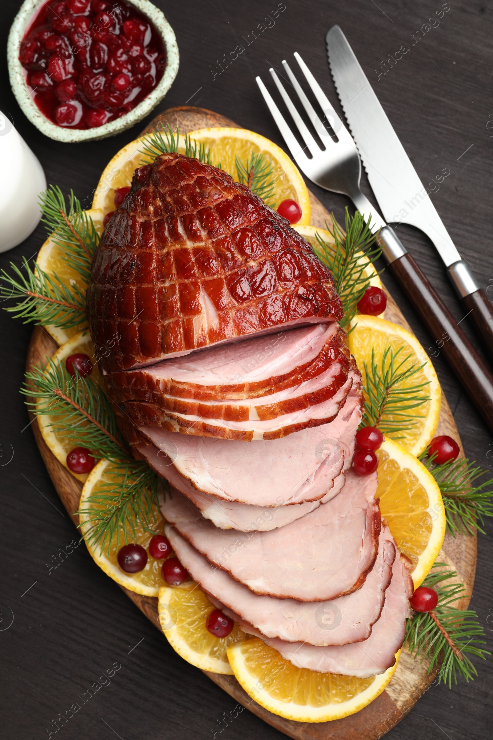 Photo of Tasty baked ham served on black wooden table, flat lay