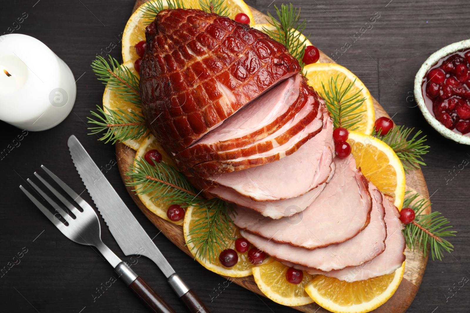 Photo of Tasty baked ham served on black wooden table, flat lay