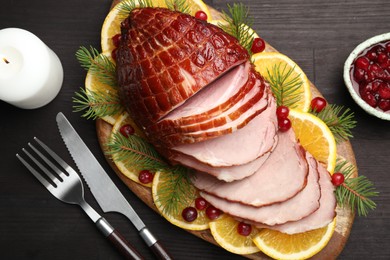 Photo of Tasty baked ham served on black wooden table, flat lay