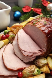 Photo of Tasty baked ham served with vegetables and oranges on table, closeup