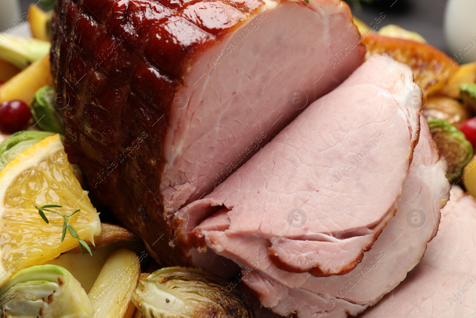 Photo of Tasty baked ham served with vegetables and oranges on table, closeup