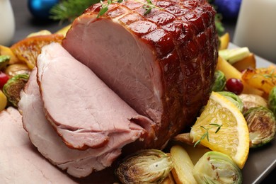 Photo of Tasty baked ham served with vegetables and oranges on table, closeup