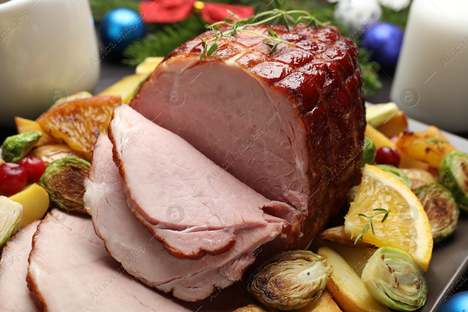 Photo of Tasty baked ham served with vegetables and oranges on table, closeup