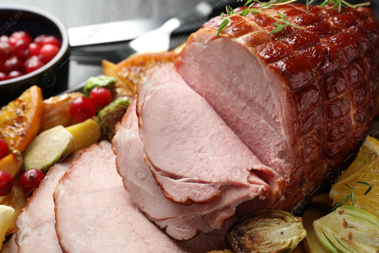 Photo of Tasty baked ham served with vegetables and oranges on table, closeup