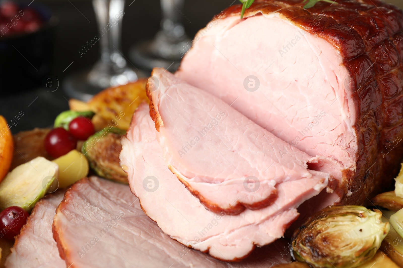 Photo of Tasty baked ham served with vegetables and oranges on table, closeup