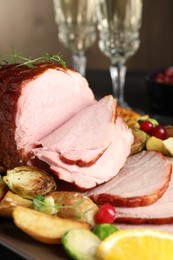 Tasty baked ham served with vegetables and oranges on table, closeup