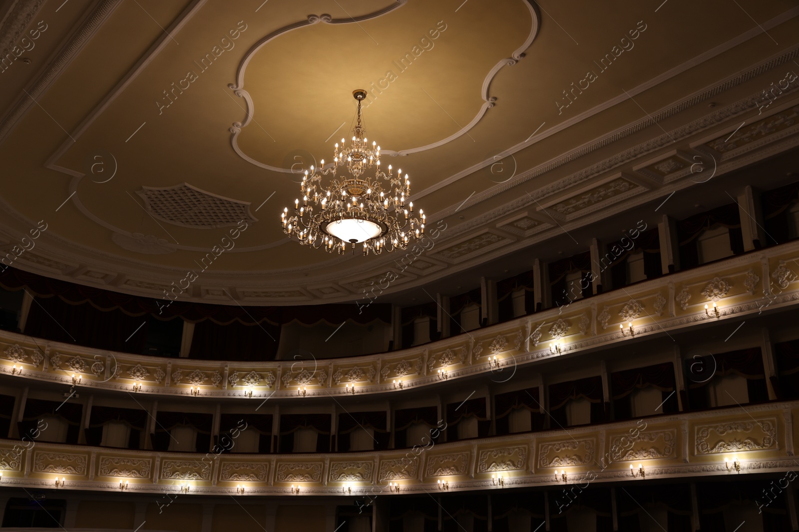 Photo of Stylish vintage chandelier in theatre, low angle view