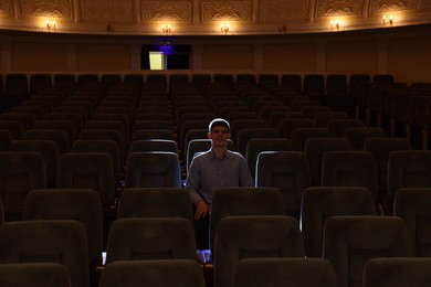 Photo of Young man watching theatrical performance in theatre