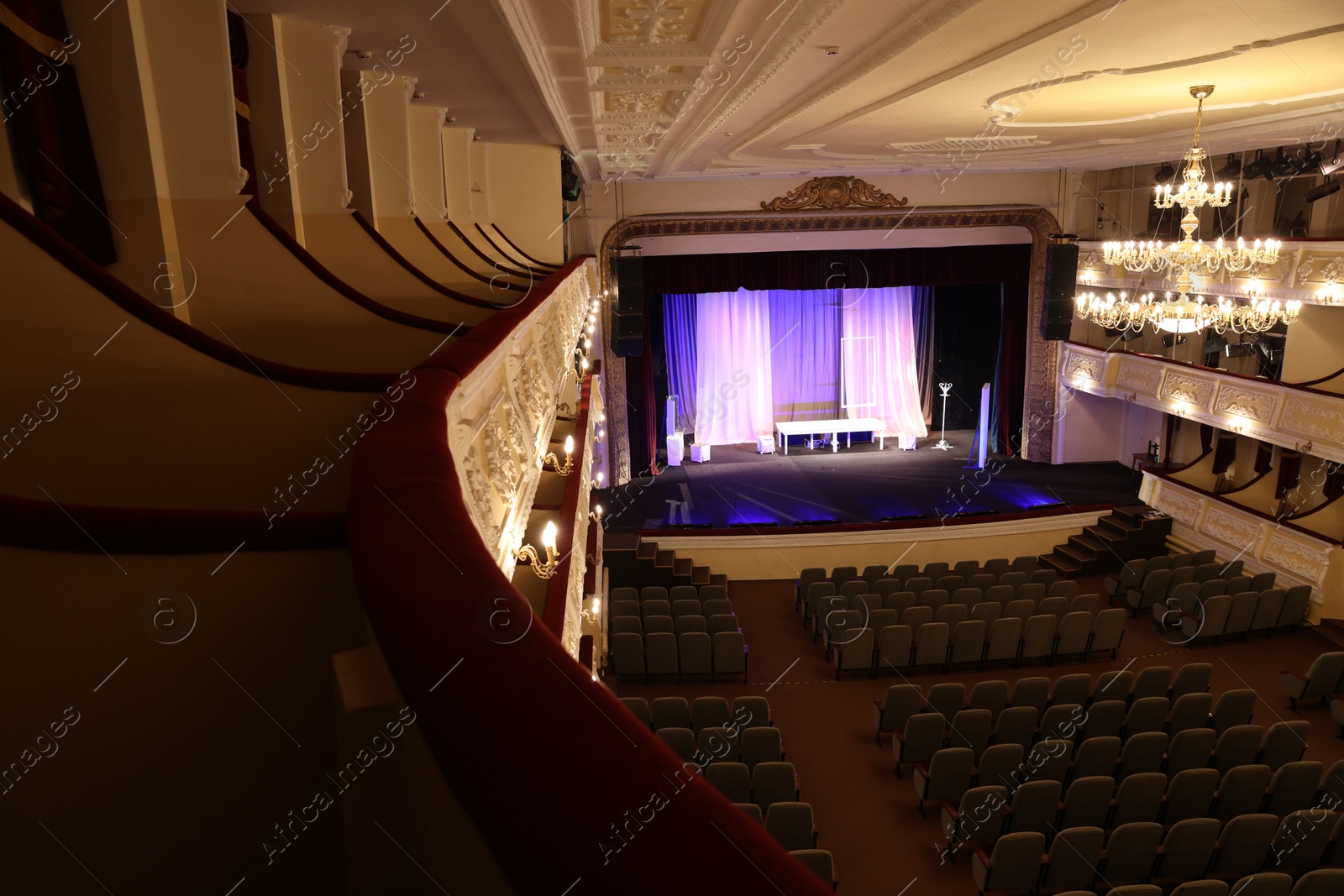 Photo of Theatre interior with stage, rows of comfortable seats and beautiful chandelier