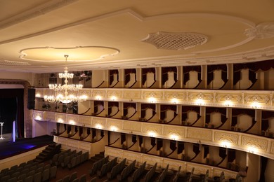 Photo of Stylish vintage chandelier on ceiling in theatre