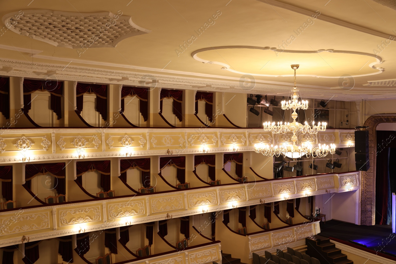 Photo of Stylish vintage chandelier on ceiling in theatre