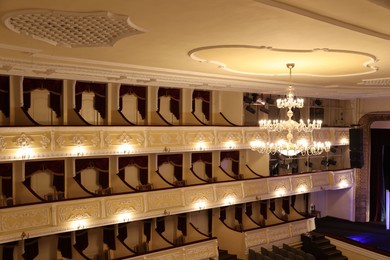 Photo of Stylish vintage chandelier on ceiling in theatre