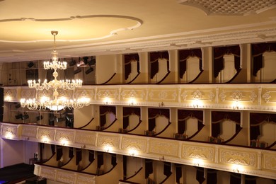 Photo of Stylish vintage chandelier on ceiling in theatre