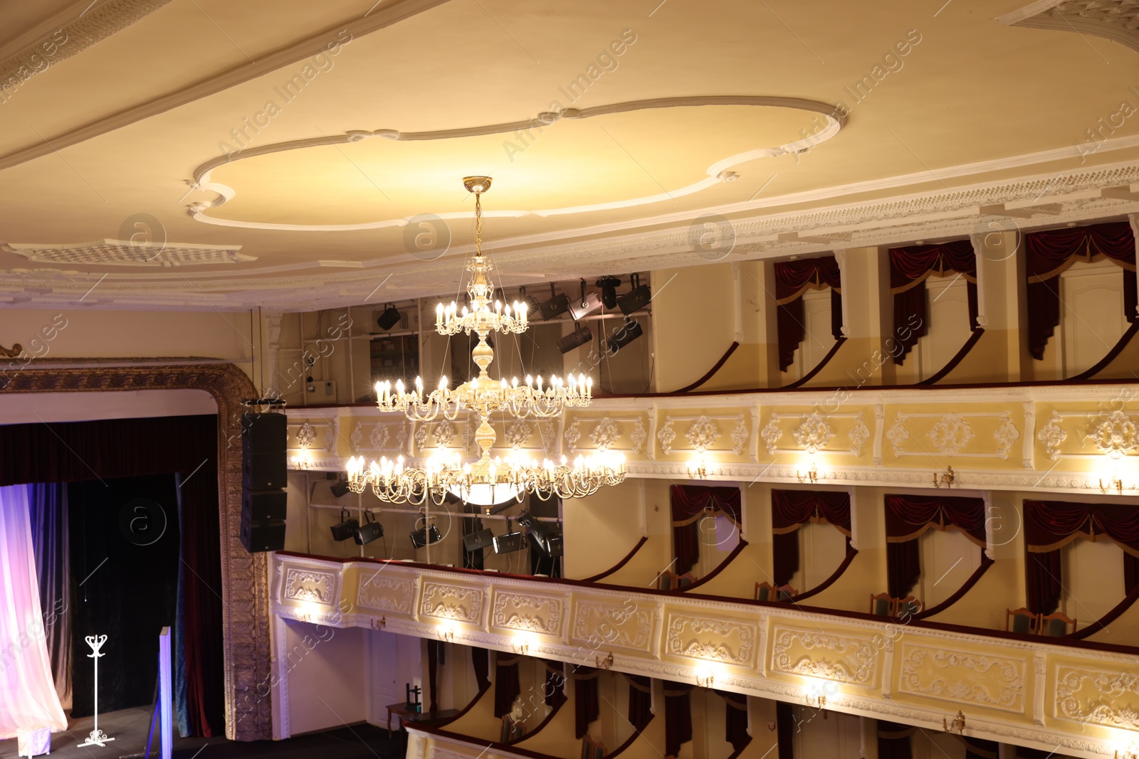 Photo of Stylish vintage chandelier on ceiling in theatre