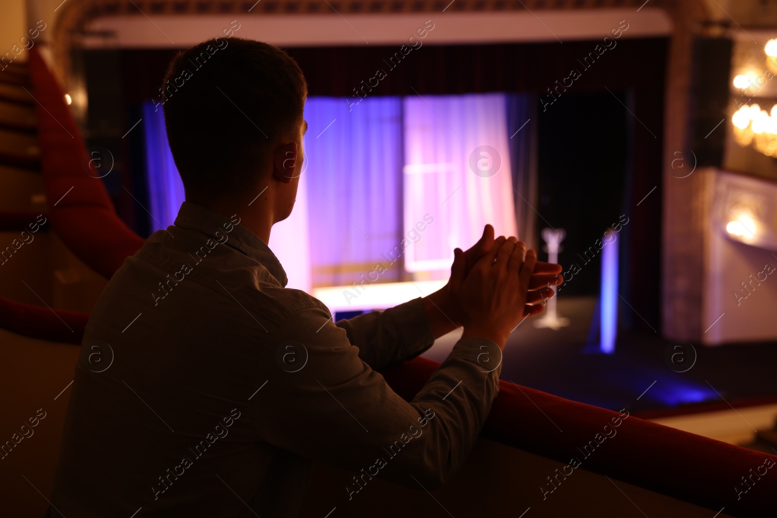 Photo of Young man watching theatrical performance in theatre