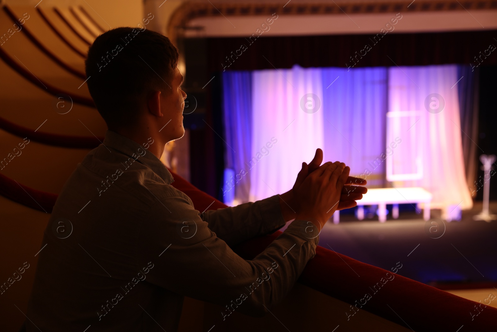 Photo of Young man watching theatrical performance in theatre