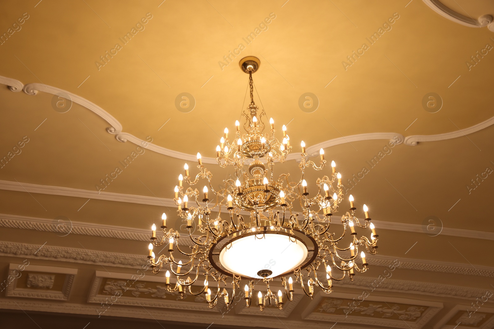 Photo of Stylish vintage chandelier in theatre, low angle view