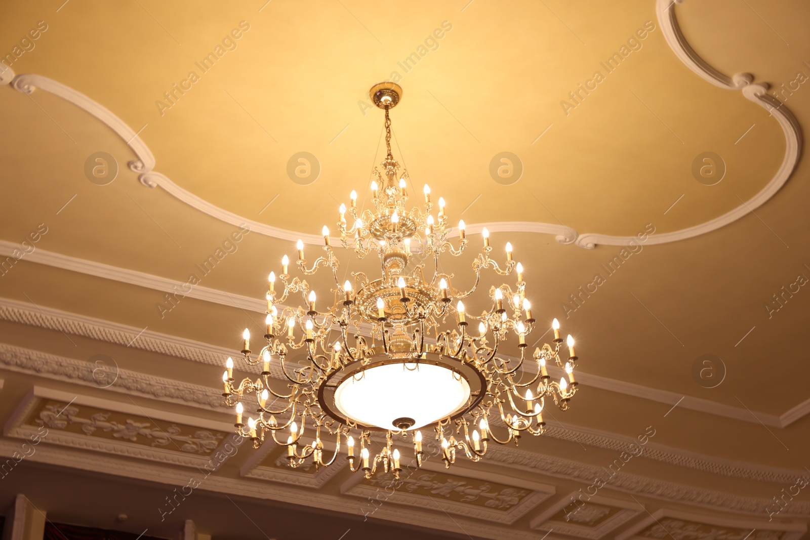 Photo of Stylish vintage chandelier in theatre, low angle view