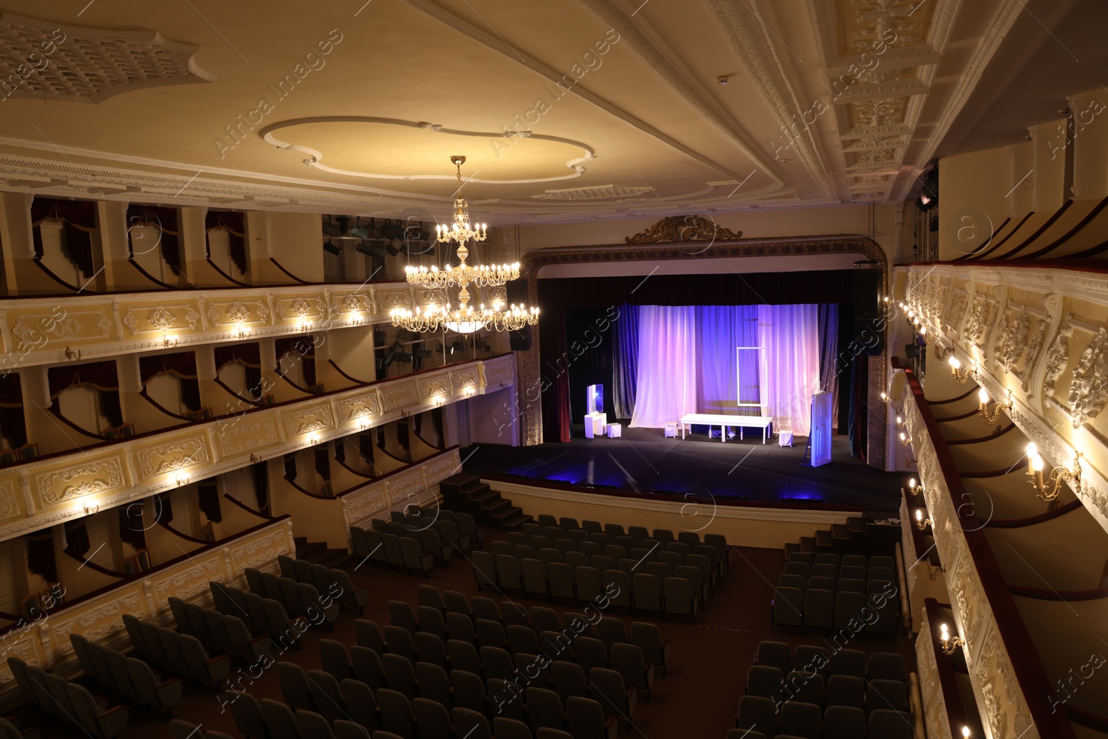 Photo of Theatre interior with stage, rows of comfortable seats and beautiful chandelier