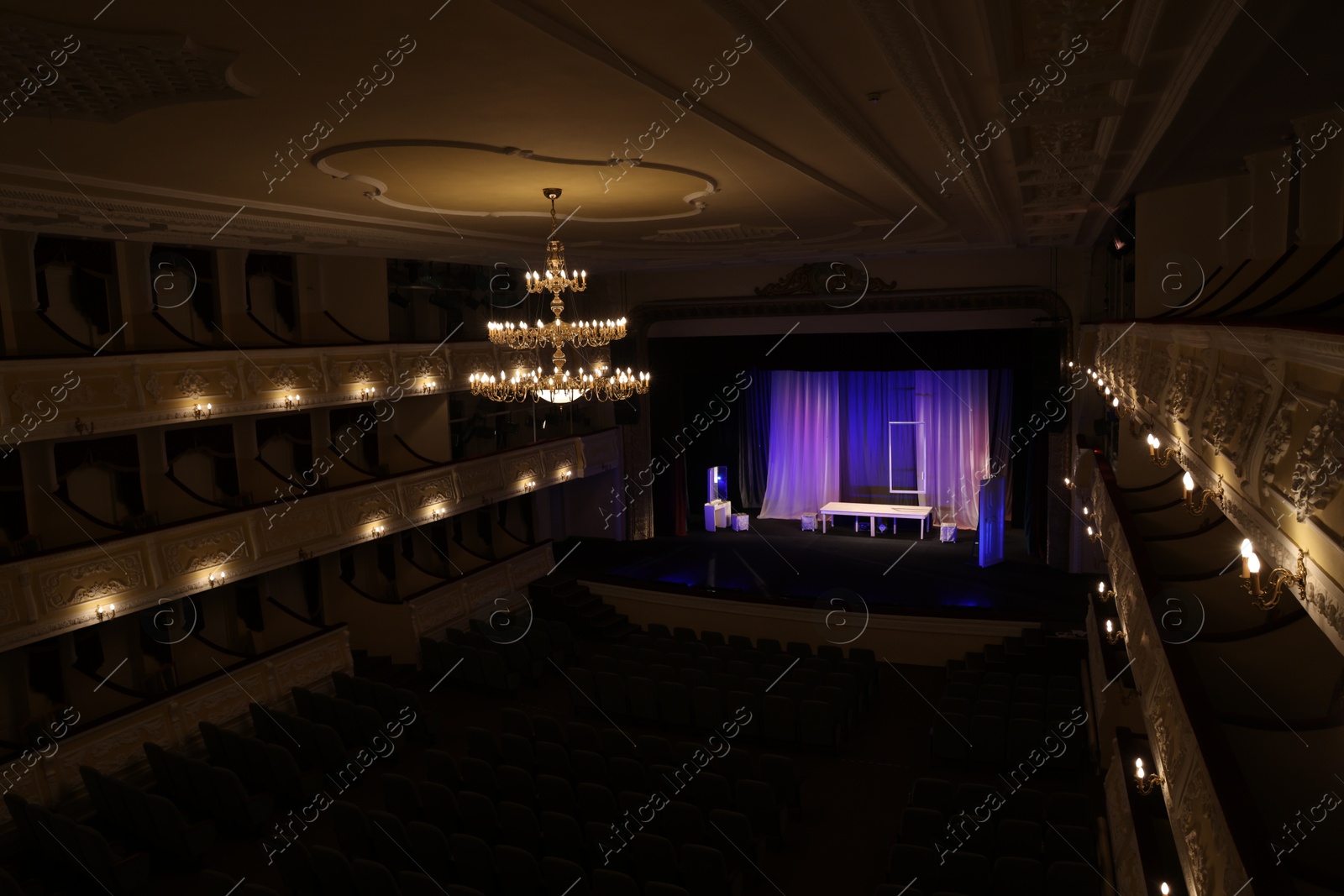 Photo of Theatre interior with stage, rows of comfortable seats and beautiful chandelier