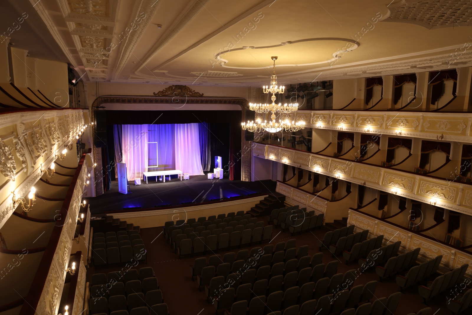 Photo of Theatre interior with stage, rows of comfortable seats and beautiful chandelier