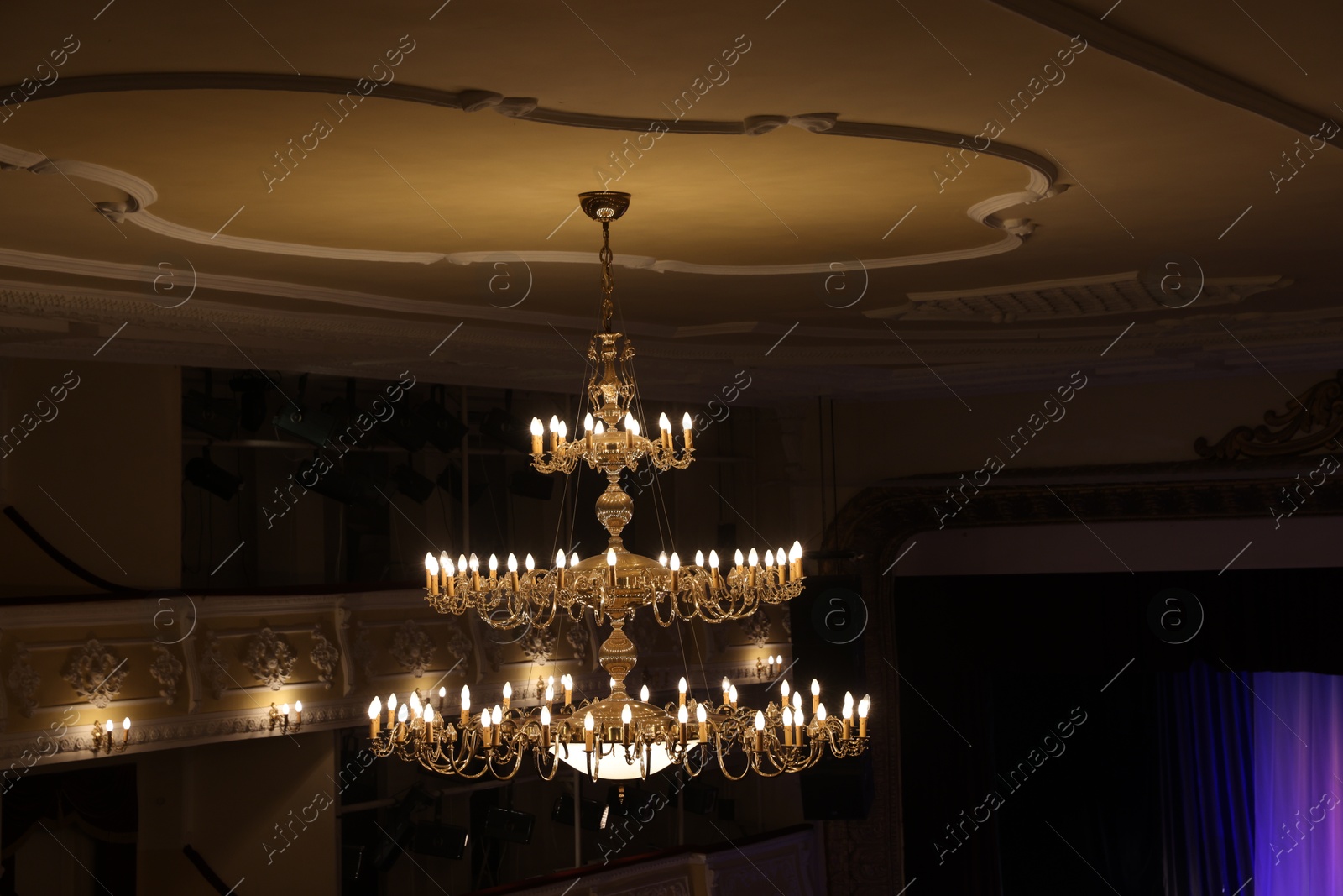 Photo of Stylish vintage chandelier on ceiling in theatre