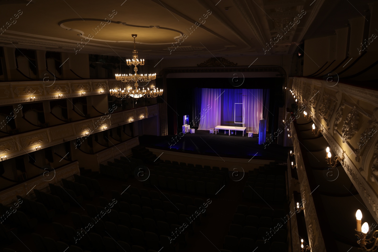 Photo of Theatre interior with stage, rows of comfortable seats and beautiful chandelier