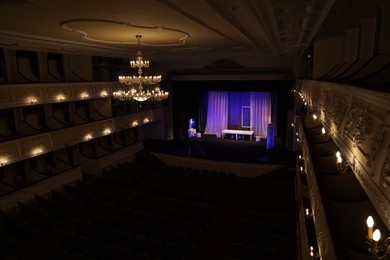 Photo of Theatre interior with stage, rows of comfortable seats and beautiful chandelier