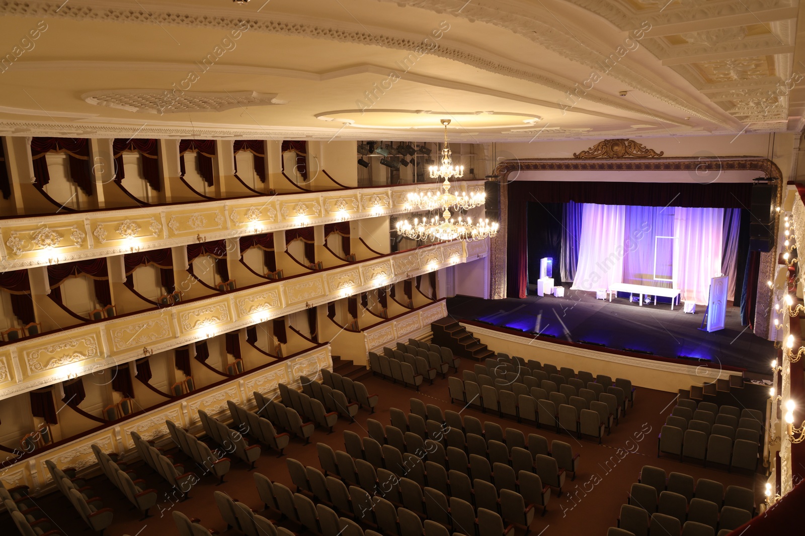 Photo of Theatre interior with stage, rows of comfortable seats and beautiful chandelier