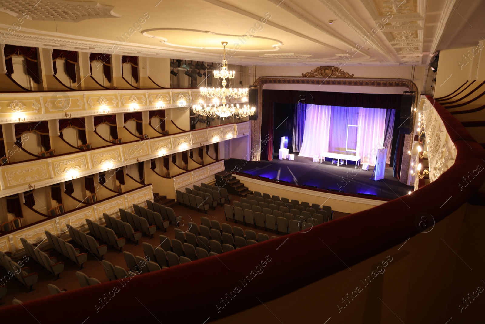 Photo of Theatre interior with stage, rows of comfortable seats and beautiful chandelier