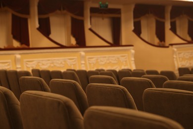 Photo of Rows of gray comfortable seats in theatre, closeup