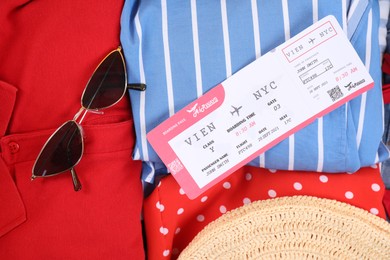 Photo of Different clothes, sunglasses and ticket as background, closeup. Travel luggage