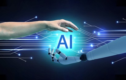 Image of AI abbreviation between human hand and robot arm on dark background with circuit board pattern