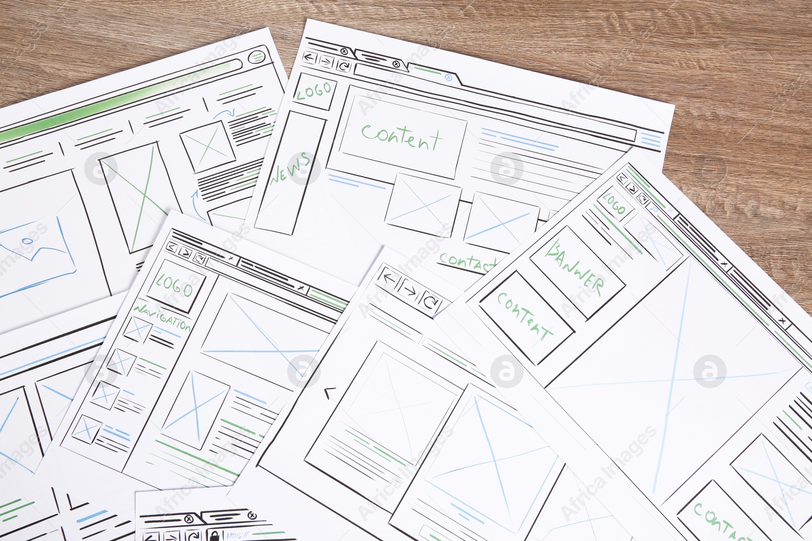 Photo of Developing UI design. Sketches of website wireframes on wooden table, top view