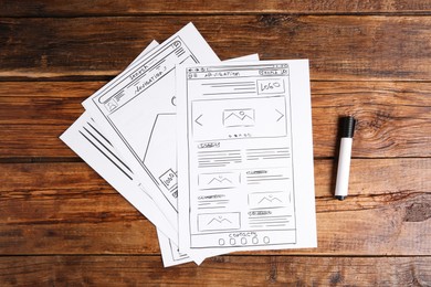 Photo of Developing UI design. Sketches of website wireframes and felt pen on wooden table, top view