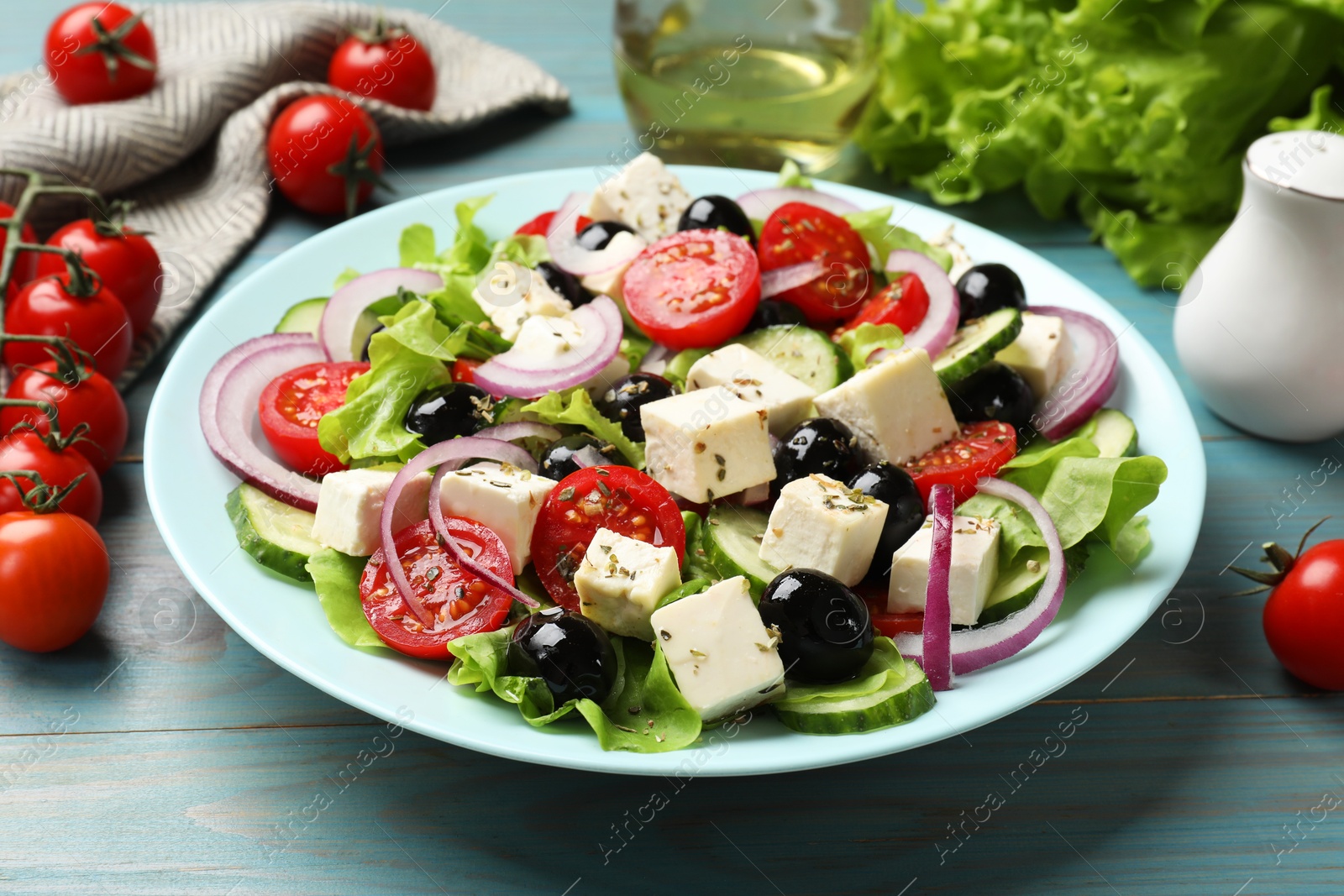 Photo of Delicious salad with feta cheese served on blue wooden table, closeup