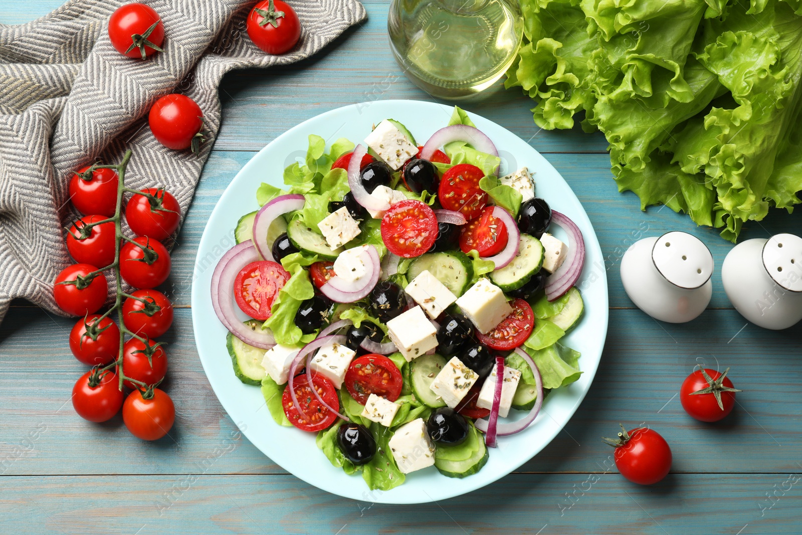 Photo of Delicious salad with feta cheese served on blue wooden table, flat lay