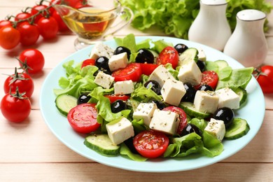 Photo of Delicious salad with feta cheese served on white wooden table, closeup