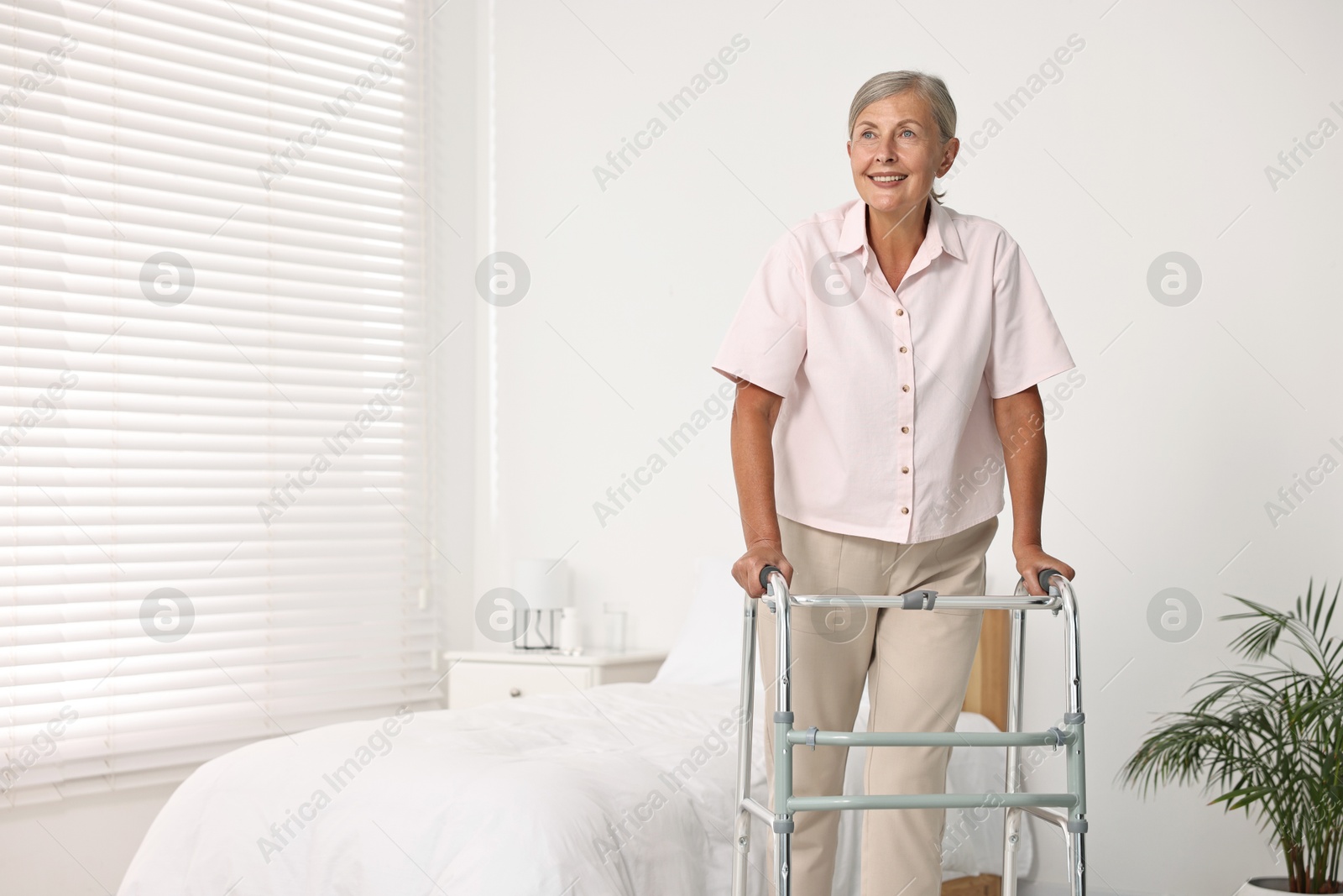 Photo of Senior woman with walking frame in hospital ward