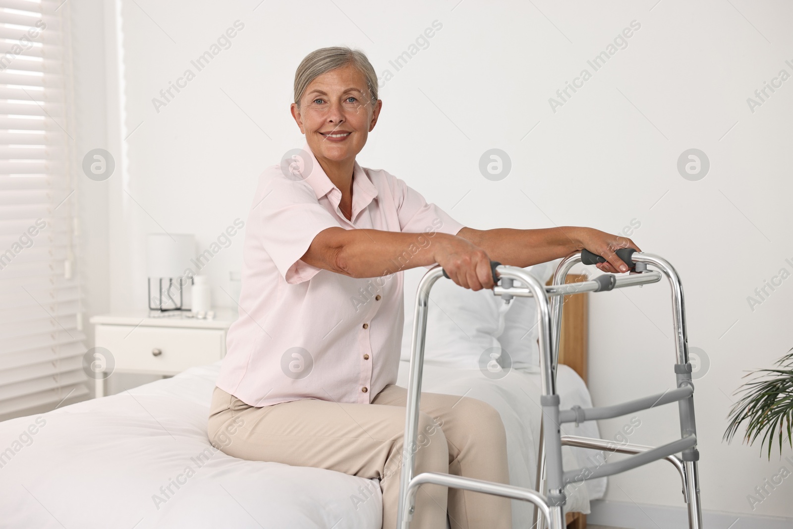 Photo of Senior woman with walking frame in hospital ward