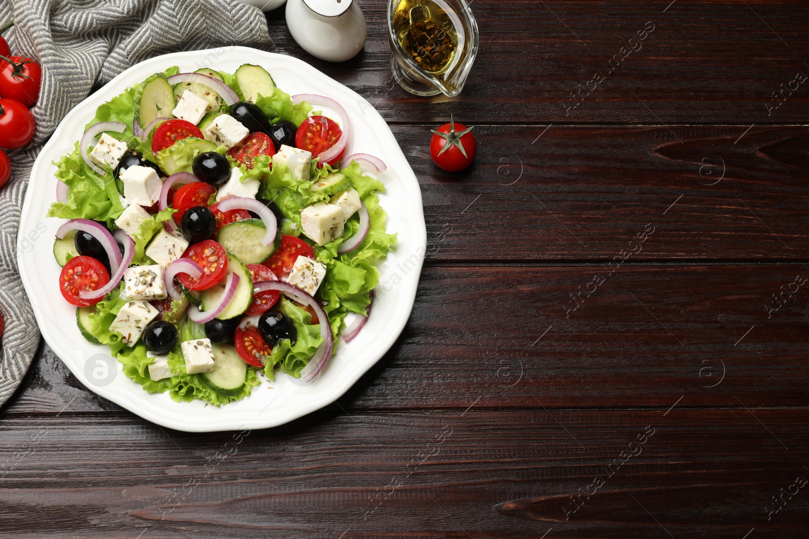 Photo of Delicious salad with feta cheese and ingredients on wooden table, flat lay. Space for text