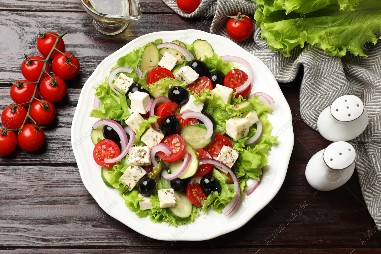 Photo of Delicious salad with feta cheese and ingredients on wooden table, flat lay