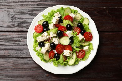 Photo of Delicious salad with feta cheese on wooden table, top view