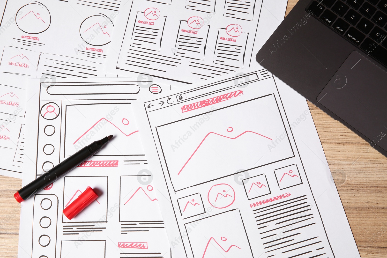 Photo of Website development. Sketches of wireframes, laptop and felt pen on wooden table, flat lay